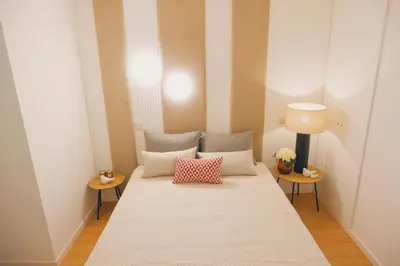 a bed in a room with two tables and a lamp at Portobello Lux Living in Vila Nova de Gaia