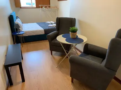 a room with two chairs and a table and a bed at Invicta House Loft Boavista in Porto