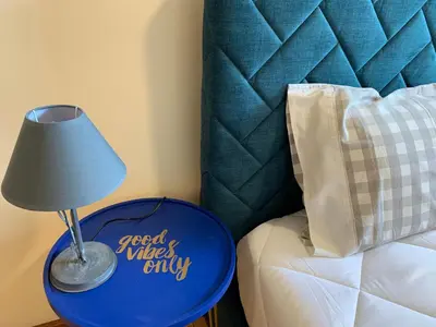 a blue table with a lamp next to a bed at Invicta House Loft Boavista in Porto