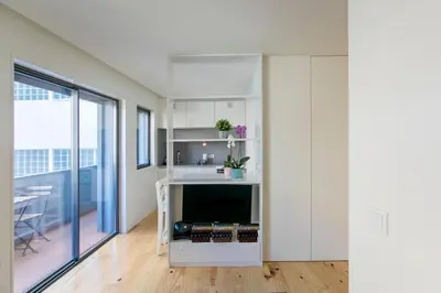 a room with white walls and a kitchen with a table at Casa São Lázaro- Terrace by Oporto Soul in Porto