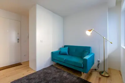 a blue chair in a room with a floor lamp at Casa São Lázaro- Terrace by Oporto Soul in Porto