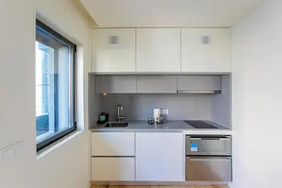 a kitchen with white cabinets and a window at Casa São Lázaro- Terrace by Oporto Soul in Porto