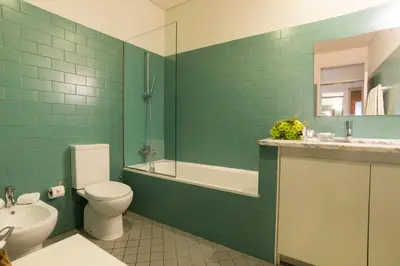 a green bathroom with a toilet and a sink at bnapartments Trindade in Porto
