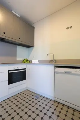 a kitchen with white cabinets and a sink at bnapartments Trindade in Porto