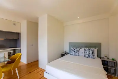 a bedroom with a large bed and a kitchen at Casa São Lázaro by Oporto Soul in Porto