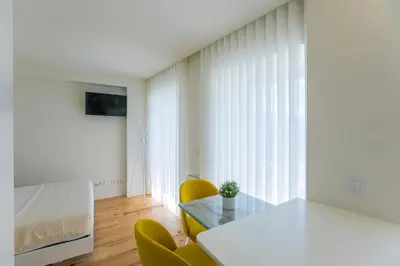 a room with a table and chairs and a bed at Casa São Lázaro by Oporto Soul in Porto