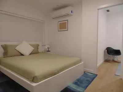 a bedroom with a bed and a black chair at Dream Modern House in Porto