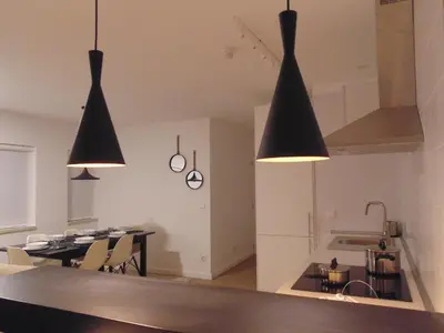 a kitchen and dining room with two black pendant lights at Dream Modern House in Porto