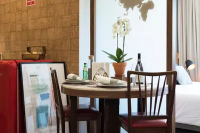 a dining room table with two chairs and a bottle of wine at CN150 boutique studio, charming flat in Porto