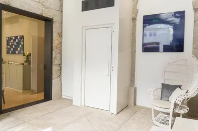 a hallway with a white door and a white chair at D'Autor Apartments Alegria in Porto