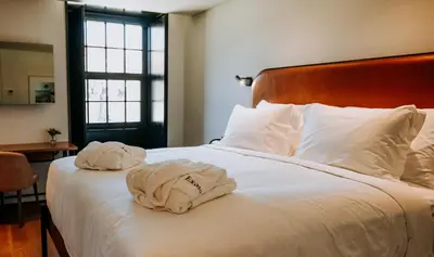 a bedroom with a bed and a chair and a table at Exmo Hotel by Olivia in Porto