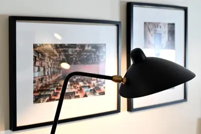 a black lamp in front of two pictures on a wall at Oporto Chic&Cozy - Batalha II in Porto