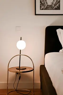 a lamp sitting on a table next to a bed at Oporto Chic&Cozy - Batalha II in Porto
