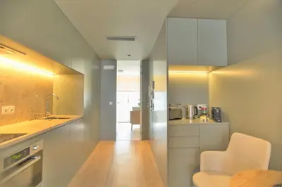 a small kitchen with white cabinets and a sink at Clérigos Prime Suites by Porto City Hosts in Porto