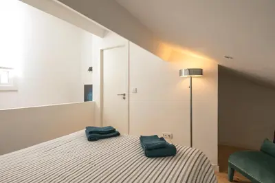 a bedroom with a bed with two green towels on it at New Bluebell house in heart of Porto in Porto