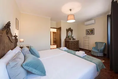a bedroom with a large white bed with blue pillows at LovelyStay - Heritage Collection House with 4Bedrooms in Porto