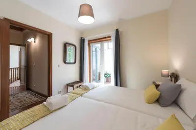 a bedroom with a large white bed and a window at LovelyStay - Heritage Collection House with 4Bedrooms in Porto
