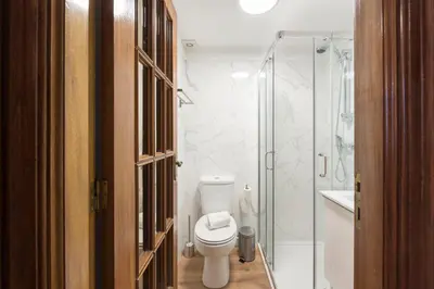 a bathroom with a toilet and a glass shower at LovelyStay - Heritage Collection House with 4Bedrooms in Porto