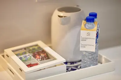 a bottle of water sitting in a drawer next to a cup at Signature Apartments Santa Catarina in Porto