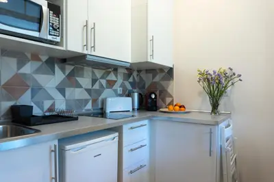 a kitchen with white cabinets and a vase of oranges at Jardim de São Lázaro - Porto Apartments in Porto