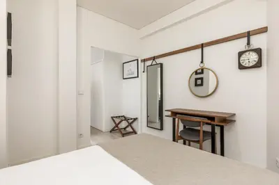 a bedroom with a desk and a clock on the wall at Bra.com Apartments Oporto Faria Guimarães in Porto