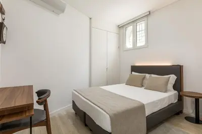 a bedroom with a bed and a desk and a window at Bra.com Apartments Oporto Faria Guimarães in Porto