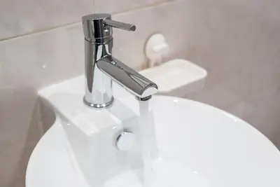 a silver faucet on a white toilet in a bathroom at GuestReady - Music Flats 2 in Porto