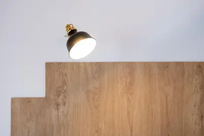 a light hanging from a wall with a wooden floor at GuestReady - Music Flats 2 in Porto