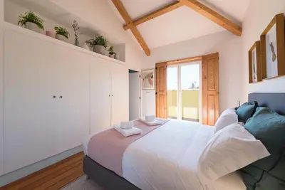 a bedroom with a large white bed and a window at Cardosas Palace Apartment in Porto