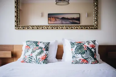 a bedroom with a bed with pillows and a mirror at Spacious 1BR with Parking in Quiet Area in Vila Nova de Gaia