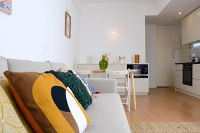 a living room with a couch and a kitchen at Travel and Live Apartments in Porto