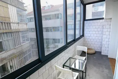 a balcony with two chairs and two windows at Travel and Live Apartments in Porto