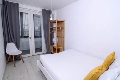 a white bedroom with a bed and a window at Travel and Live Apartments in Porto