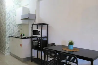 a kitchen with a table and chairs and a microwave at Bonsai Apartment I in Porto