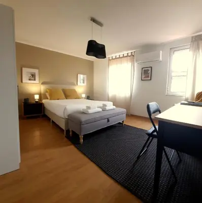a bedroom with a white bed and a black rug at Downtown Porto Spot - 2 bedroom Apartment in Porto