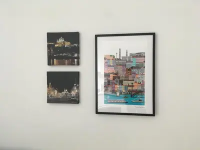three framed photographs hanging on a white wall at Porta de São Bento in Porto