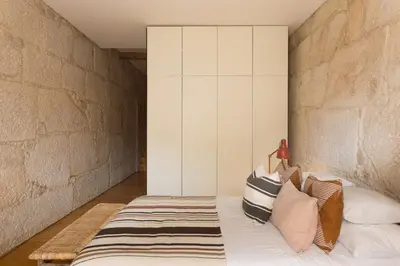 a bedroom with a bed with pillows on it at Casa Castanha in Porto