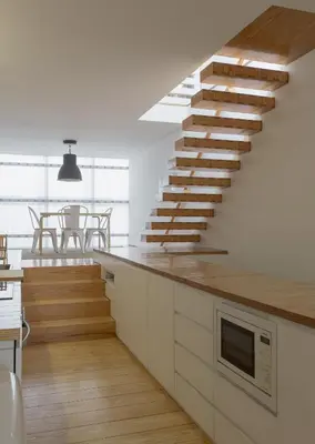 a kitchen with a staircase leading up to a living room at Casa Castanha in Porto