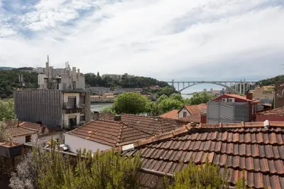 a view of a city with roofs and a bridge at Casa Castanha in Porto
