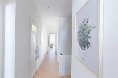 a hallway with white walls and a white hallway with a picture on the wall at GuestReady - Costa Cabral Guesthouse in Porto