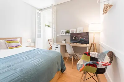 a bedroom with a bed and a desk and chairs at GuestReady - Costa Cabral Guesthouse in Porto