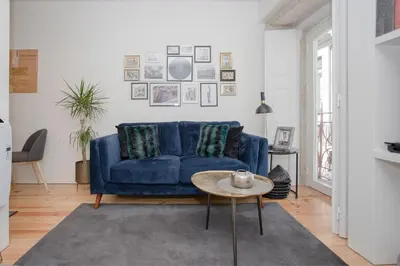 a living room with a blue couch and a table at Liiiving in Porto - Cozy & Chic Downtown in Porto