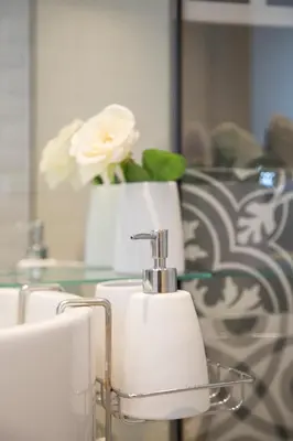 a bathroom with a sink and a vase with a flower at Liiiving in Porto - Cozy & Chic Downtown in Porto