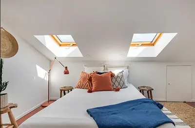 a bedroom with two skylights and a bed with pillows at Oak Valley Flats Porto Santa Catarina in Porto