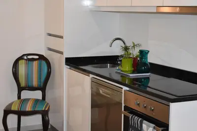 a small kitchen with a sink and a chair at Casa Barão Forrester in Porto