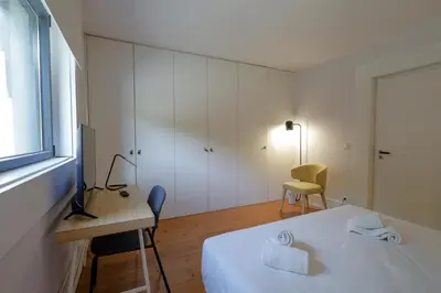 a bedroom with a large white bed and a window at Douro Destilaria Residence by Porto City Hosts in Vila Nova de Gaia