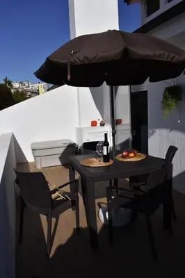 a table and chairs under an umbrella on a balcony at Terraço da Boavista in Porto