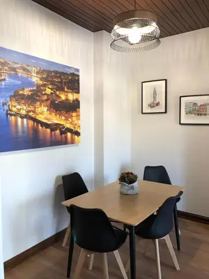 a dining room table with chairs and a painting on the wall at Terraço da Boavista in Porto