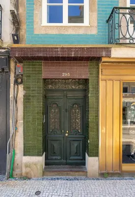 a green door on the side of a building at Cedofeita Deluxe Apartment 3F in Porto