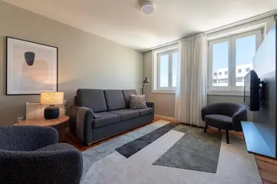 a living room with a couch and a tv at Cedofeita Deluxe Apartment 3B in Porto